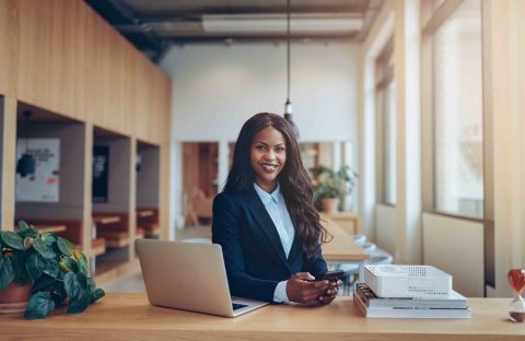 African businesswoman smiling at desk 299130290